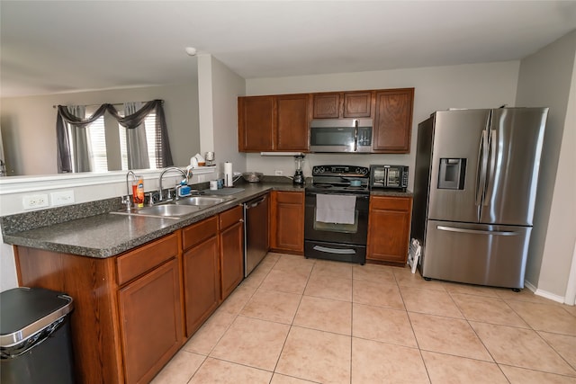 kitchen featuring kitchen peninsula, light tile patterned floors, stainless steel appliances, and sink