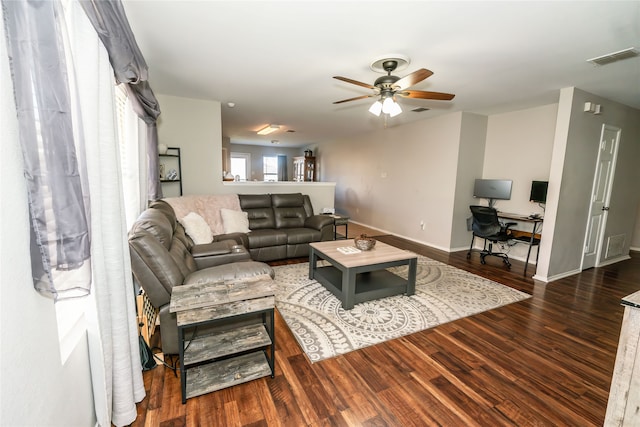 living room featuring ceiling fan and dark wood-type flooring