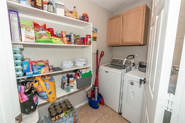 laundry area with washer and dryer, light tile patterned flooring, and cabinets