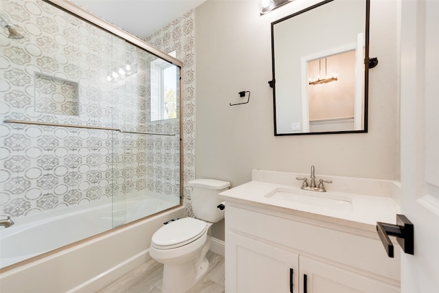 full bathroom featuring toilet, combined bath / shower with glass door, and vanity