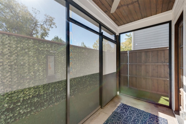 unfurnished sunroom featuring ceiling fan and wood ceiling