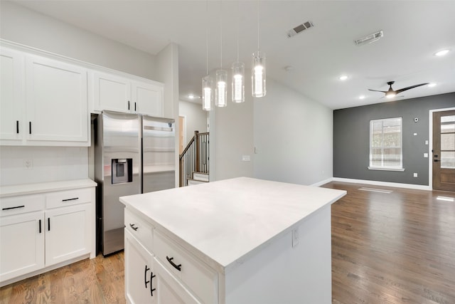 kitchen featuring white cabinets, stainless steel fridge with ice dispenser, a center island, and ceiling fan