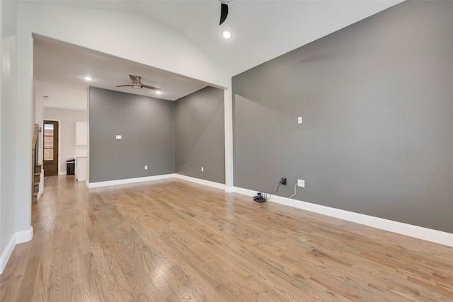 spare room featuring ceiling fan, light wood-type flooring, and lofted ceiling