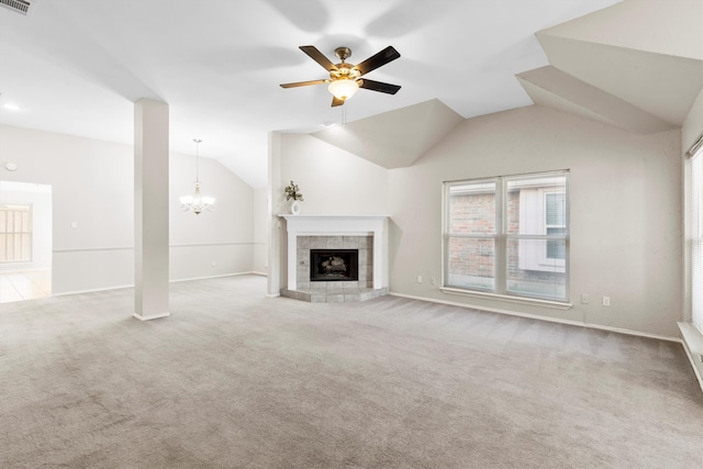 unfurnished living room featuring ceiling fan with notable chandelier, carpet floors, vaulted ceiling, and a fireplace