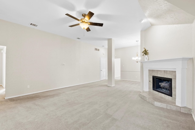 unfurnished living room featuring ceiling fan with notable chandelier, lofted ceiling, light carpet, and a tiled fireplace