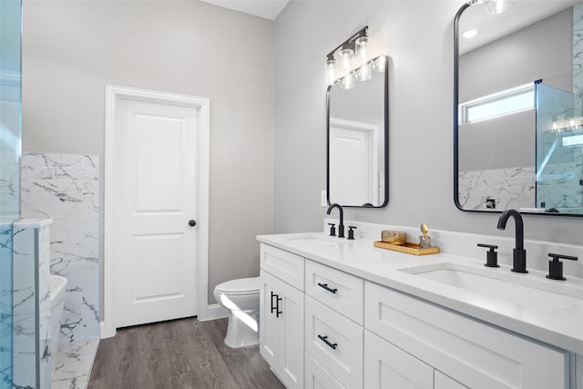 bathroom featuring hardwood / wood-style floors, vanity, toilet, and a tub