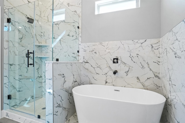 bathroom with tile walls and independent shower and bath