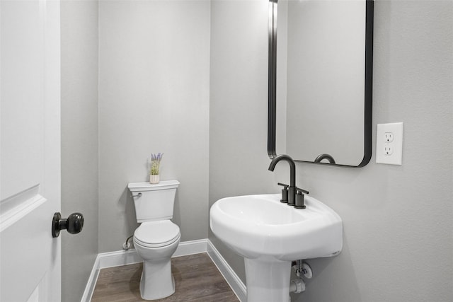 bathroom with sink, hardwood / wood-style floors, and toilet