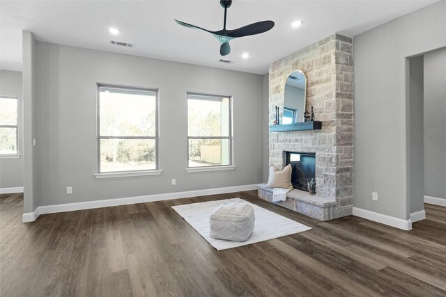 unfurnished living room featuring a fireplace, dark hardwood / wood-style flooring, ceiling fan, and a healthy amount of sunlight