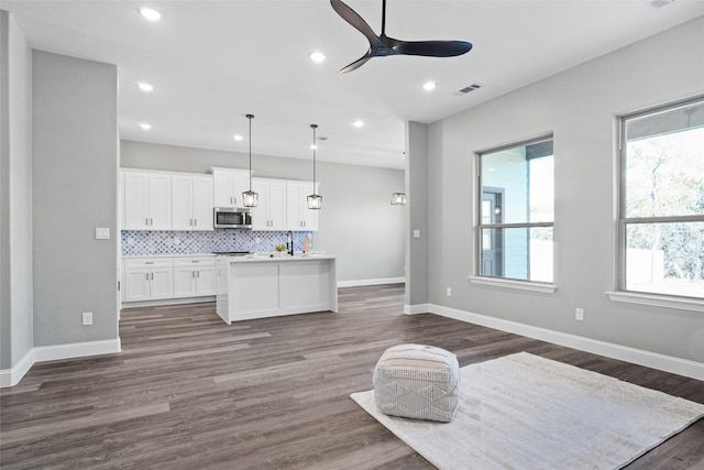 kitchen featuring white cabinetry, ceiling fan, hanging light fixtures, tasteful backsplash, and dark hardwood / wood-style floors