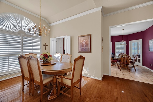 dining space with ornamental molding, wood-type flooring, and a notable chandelier