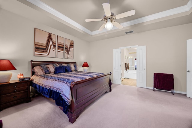 carpeted bedroom featuring ceiling fan, a raised ceiling, ornamental molding, and ensuite bath