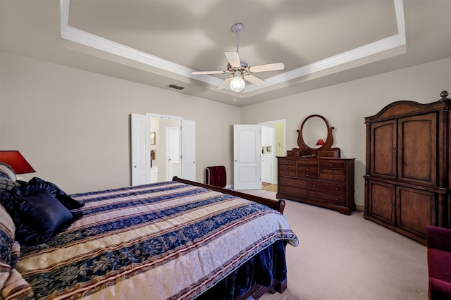 carpeted bedroom with a raised ceiling and ceiling fan