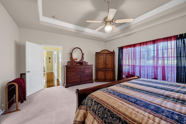 bedroom featuring light carpet, a raised ceiling, and ceiling fan