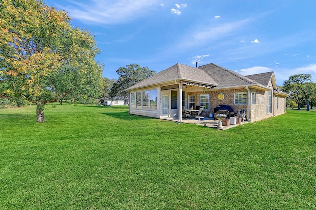 rear view of house with a yard and a patio