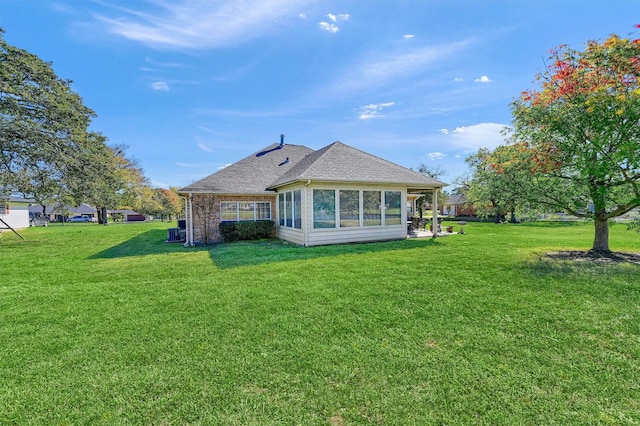 back of property featuring a sunroom and a yard