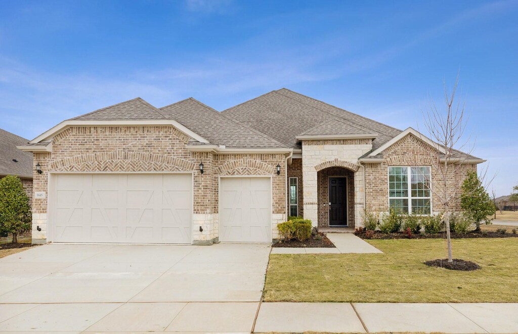 view of front of home featuring a lawn and a garage