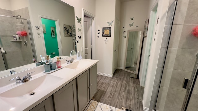 bathroom featuring wood-type flooring, vanity, and a shower with door