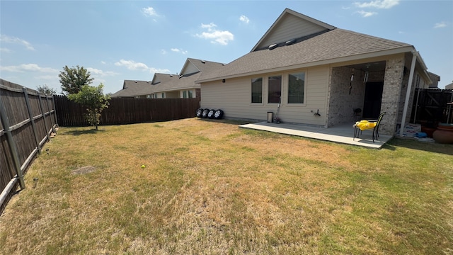 rear view of property with a lawn and a patio area