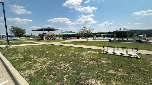 view of home's community featuring a playground and a yard