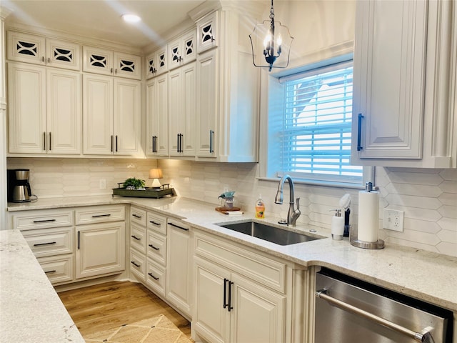 kitchen featuring dishwasher, decorative backsplash, decorative light fixtures, and sink