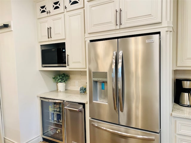 kitchen with wine cooler, decorative backsplash, stainless steel appliances, and light stone counters