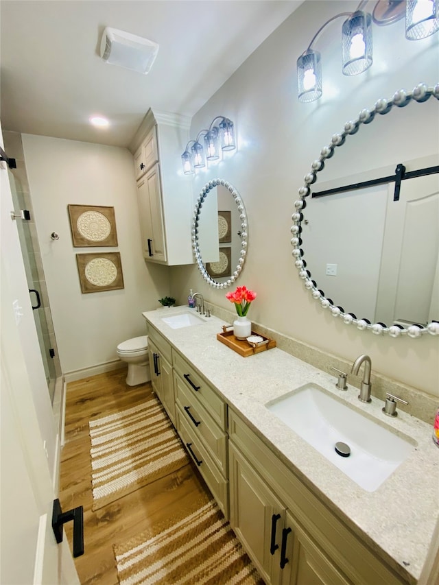 bathroom featuring hardwood / wood-style floors, vanity, toilet, and an enclosed shower