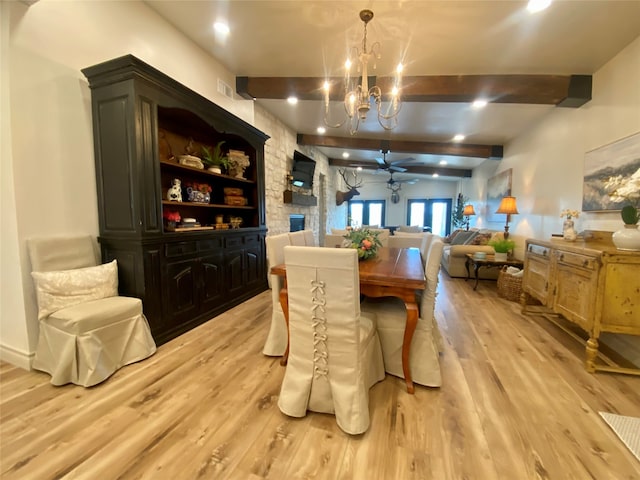 dining area featuring beamed ceiling, ceiling fan with notable chandelier, and light wood-type flooring