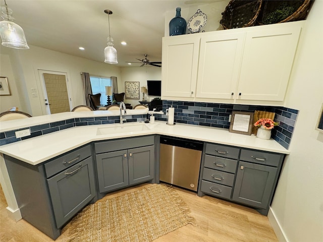 kitchen featuring gray cabinetry, sink, light hardwood / wood-style flooring, stainless steel dishwasher, and ceiling fan