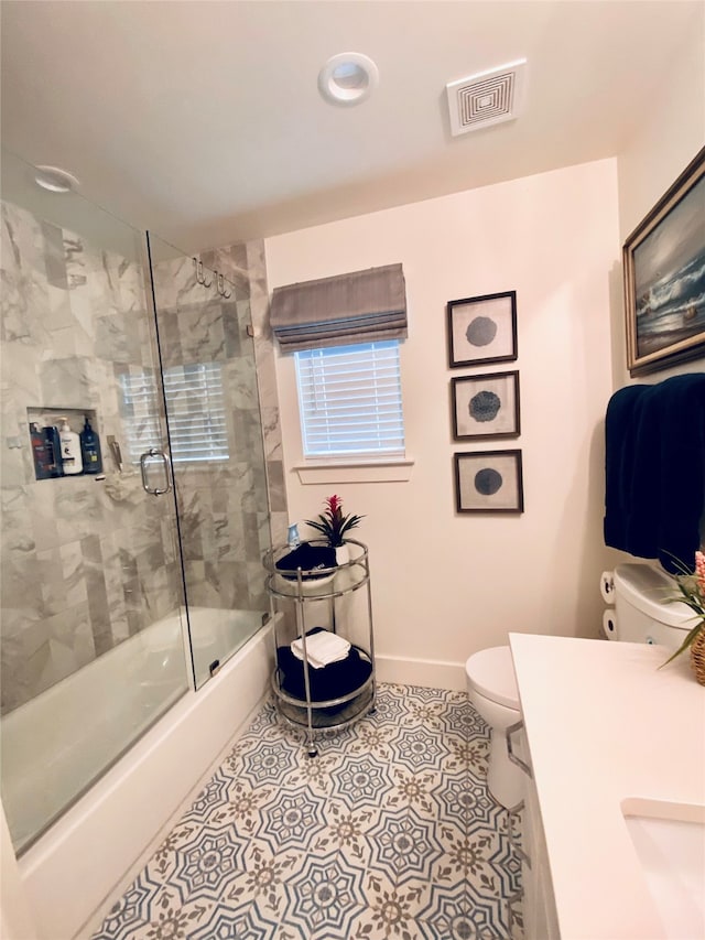 full bathroom with tile patterned flooring, vanity, toilet, and bath / shower combo with glass door