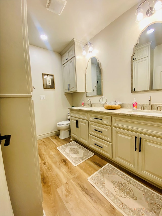 bathroom with hardwood / wood-style flooring, vanity, and toilet