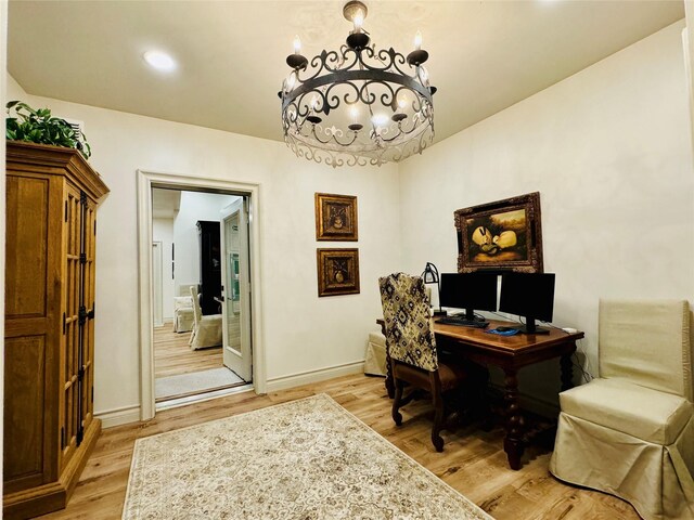 office featuring light wood-type flooring and an inviting chandelier