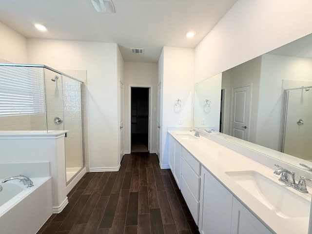 bathroom featuring plus walk in shower, vanity, and hardwood / wood-style flooring