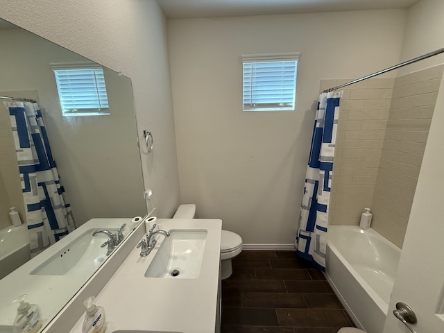 full bathroom with sink, shower / bathtub combination with curtain, hardwood / wood-style floors, and toilet