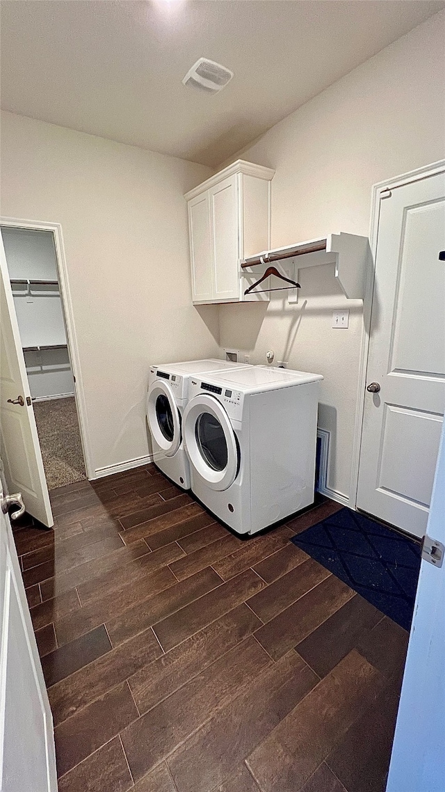 laundry area featuring cabinets, dark hardwood / wood-style flooring, and independent washer and dryer