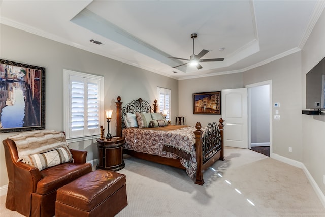 bedroom featuring a tray ceiling, ceiling fan, carpet floors, and ornamental molding