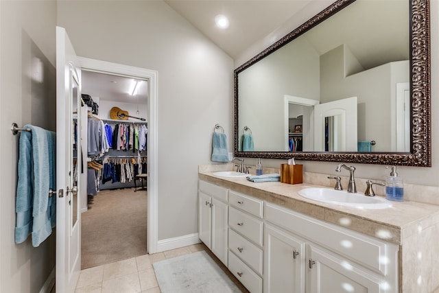 bathroom with tile patterned floors, vanity, and lofted ceiling