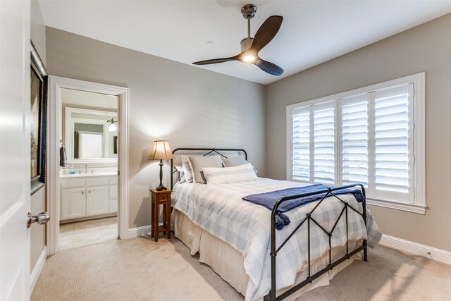 carpeted bedroom with ceiling fan, sink, and ensuite bath