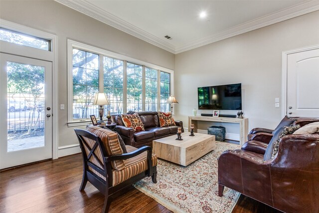 living room featuring a healthy amount of sunlight, ornamental molding, and dark wood-type flooring