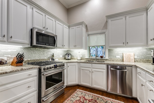 kitchen with sink, decorative backsplash, appliances with stainless steel finishes, dark hardwood / wood-style flooring, and white cabinetry