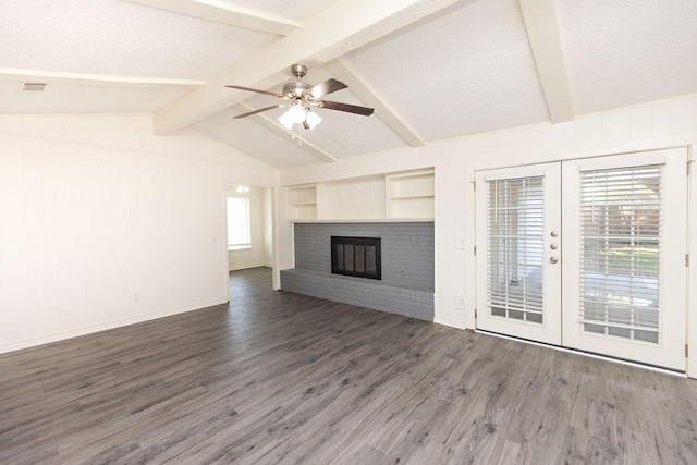 unfurnished living room featuring dark wood-style floors, french doors, a fireplace, lofted ceiling with beams, and ceiling fan