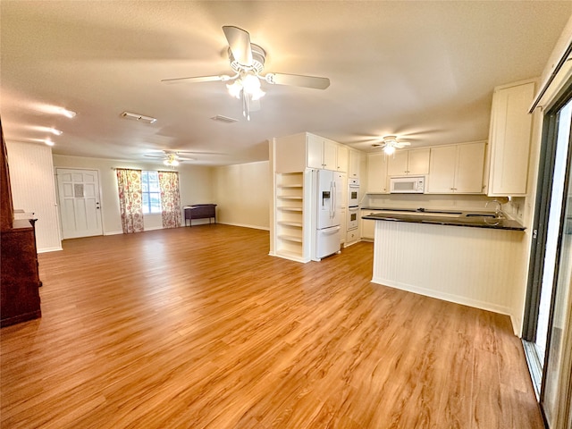 unfurnished living room featuring sink and light hardwood / wood-style floors