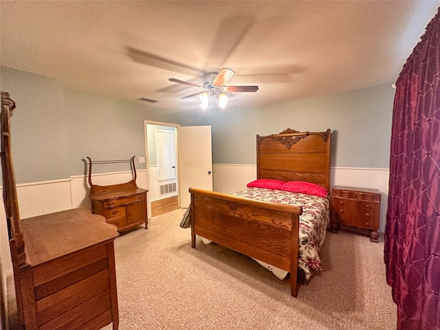 carpeted bedroom with ceiling fan and a textured ceiling