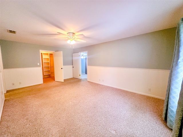 unfurnished bedroom with a walk in closet, ceiling fan, and a closet