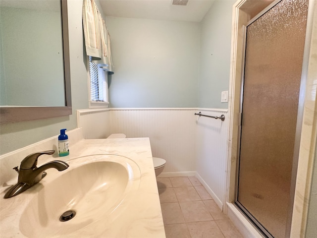 bathroom with tile patterned floors, vanity, toilet, and walk in shower