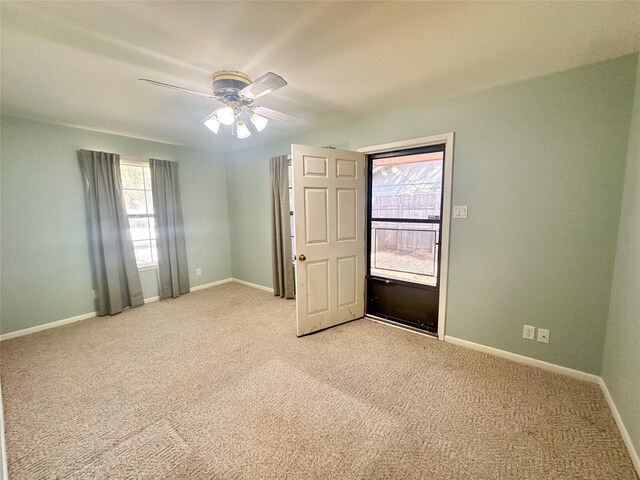 carpeted spare room featuring ceiling fan