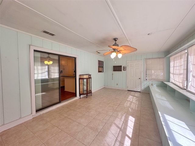 interior space with light tile patterned floors and ceiling fan