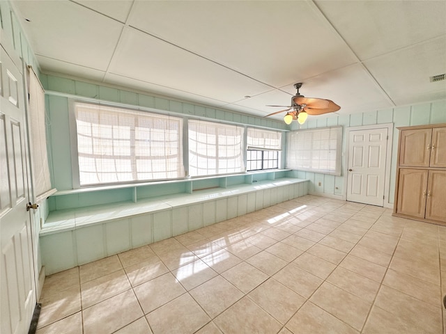 unfurnished sunroom with ceiling fan