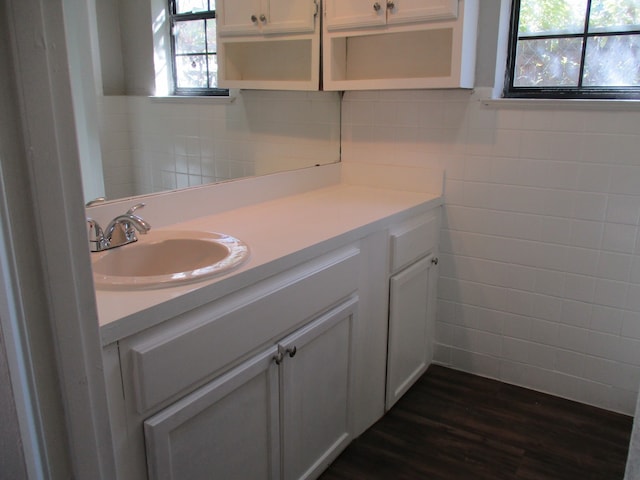 bathroom featuring vanity, wood-type flooring, and tile walls