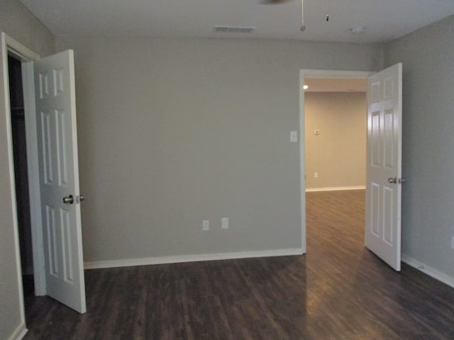 spare room featuring ceiling fan and dark hardwood / wood-style floors